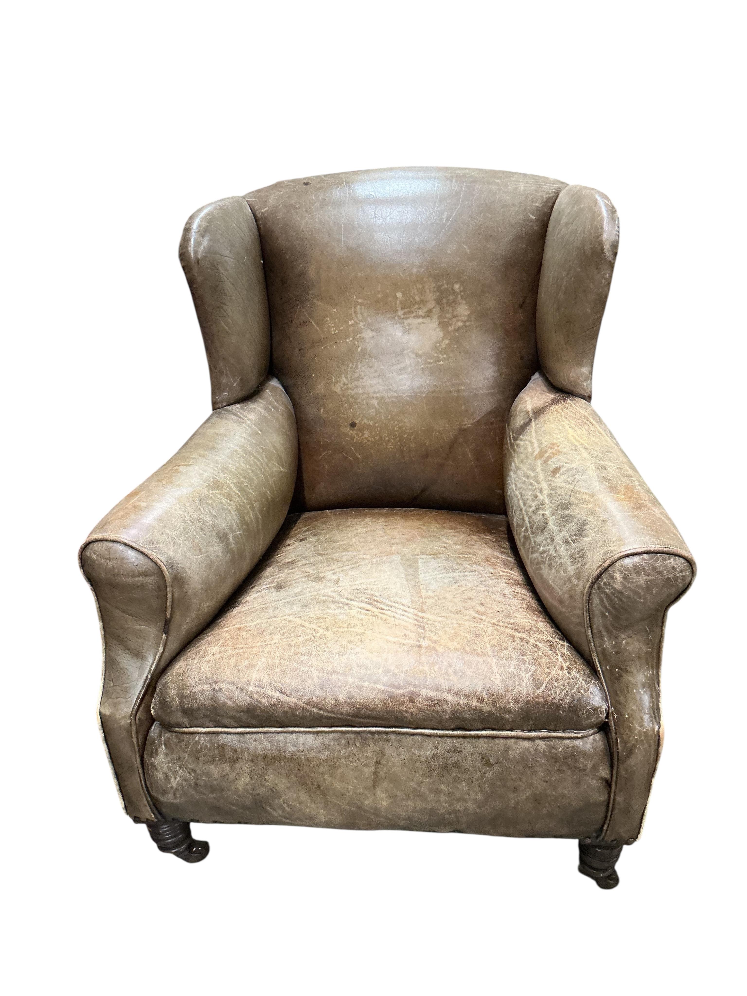 A pair of late Victorian brown leather wing armchairs, width 78cm, depth 76cm, height 89cm